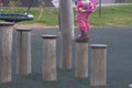 A child walks on a wooden log in a children& x27;s park, a kid overcomes obstacles, plays on a children& x27;s playground