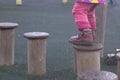 A child walks on a wooden log in a children's park, a kid overcomes obstacles, plays on a children's playground