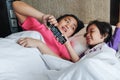 Asian Little Boy On Bed Wants to Take Over Television Remote Control from His Mother. Family Feud Royalty Free Stock Photo