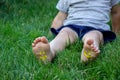 The child was lying on the green grass. Smile with paints on the legs and arms. Child having fun outdoors in the spring Royalty Free Stock Photo