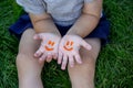 The child was lying on the green grass. Smile with paints on the legs and arms. Child having fun outdoors in the spring Royalty Free Stock Photo