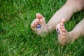 The child was lying on the green grass. Smile with paints on the legs and arms. Child having fun outdoors in the spring Royalty Free Stock Photo