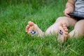 The child was lying on the green grass. Smile with paints on the legs and arms. Child having fun outdoors in the spring Royalty Free Stock Photo