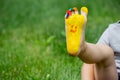 The child was lying on the green grass. Smile with paints on the legs and arms. Child having fun outdoors in the spring Royalty Free Stock Photo