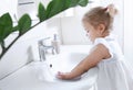 Child washes hands in bathroom.Little girl body care,hygiene concept.Covid protection