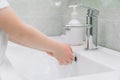 Child washes hands a small with soap over the sink with running water. Personal hygiene. Protection against COVID-19 Royalty Free Stock Photo