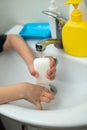 A child washes his hands with a bar of soap to prevent coronovirus