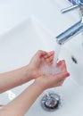 The child washes his hands in the bathroom.