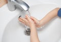 Child washes his hands in the sink