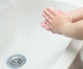 A child washes his hands with soap in the bathroom. The concept of hygiene and clean hands, infection, close-up