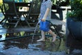 Child wasting water splashing in puddle