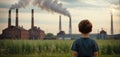 Child watches smoke coming out of the chimney and cooling tower of a power plant