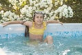 A child in the water. A girl splashes in an inflatable pool in the garden on a sunny summer day Royalty Free Stock Photo