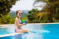 Child with water gun in swimming pool. Kids swim. Royalty Free Stock Photo