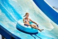 Child on water slide at aquapark. Royalty Free Stock Photo