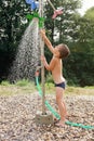 Child in water under garden shower Royalty Free Stock Photo