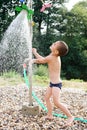 Child in water under garden shower Royalty Free Stock Photo