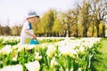 Child with watering can among tulips flowers on field Royalty Free Stock Photo