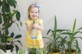 Funny little girl gardener with plants in the room at home. Royalty Free Stock Photo