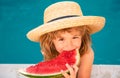 Child with watermelon in swimming pool. Kids eat summer fruit outdoors. Healthy children. Royalty Free Stock Photo