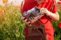 Child wathing in camera on the field with wild poppies.