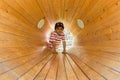 A child inside a wooden loud speaker. Casual portrait.