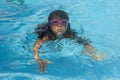 Child wearing goggles, breathing while swimming in the pool. Royalty Free Stock Photo