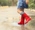 Child wearing red rain boots jumping into a puddle Royalty Free Stock Photo