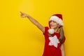 Child wearing Santa hat pointing towards blank space Royalty Free Stock Photo