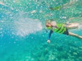 Child wearing snorkeling mask diving underwater