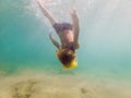 Child wearing snorkeling mask diving underwater