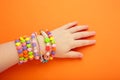 Child wears bracelets on his hands. Kids handmade beaded jewelry on orange background Royalty Free Stock Photo
