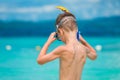 Child wears a snorkeling mask on the seashore