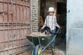 Child carries around a cat in a barrow
