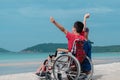 Child on wheelchair is smiling, playing, doing activity on  sea beach with father,Lifestyle of disability child, Royalty Free Stock Photo