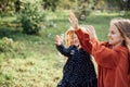 Child whirling, dancing plays on the meadow. Girl having fun with bubbles.