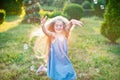 Child whirling, dancing plays on the meadow. Girl having fun with bubbles. Cute little longhair blonde girl dancing with soap Royalty Free Stock Photo