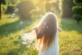 Child whirling, dancing plays on the meadow. Girl having fun with bubbles. Cute little longhair blonde girl dancing with soap Royalty Free Stock Photo