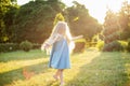 Child whirling, dancing plays on the meadow. Girl having fun with bubbles. Cute little longhair blonde girl dancing with soap Royalty Free Stock Photo