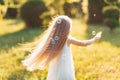 Child whirling, dancing plays on the meadow. Girl having fun with bubbles. Cute little longhair blonde girl dancing with soap Royalty Free Stock Photo