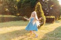 Child whirling, dancing plays on the meadow. Girl having fun with bubbles. Cute little longhair blonde girl dancing with soap. Royalty Free Stock Photo