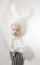 Child in a white downy bunny costume.