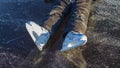 A child in white skates sits on the ice of the river stretching his legs in winter Royalty Free Stock Photo