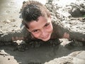 Child who has fun on the beach getting filled with wet sand, the sea for children as well as being a fantastic game is very health