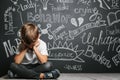 A child whose depression is on a black background with his hands closed