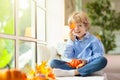 Child at window in autumn. Kids at home in fall Royalty Free Stock Photo