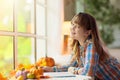 Child at window in autumn. Kids at home in fall Royalty Free Stock Photo