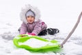 Child in winter clothes playing with sleds in the snow Royalty Free Stock Photo