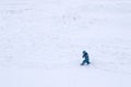 Child with winter clothes walking in a snowfield Royalty Free Stock Photo