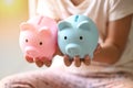 Child woman hand hold blue and pink piggy bank for saving money for education study or investment , Save money concept, daughter
